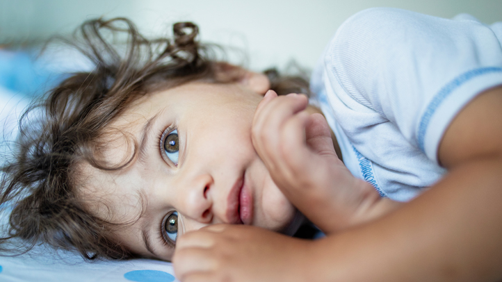 2-year sleep regression, little toddler boy lying awake in bed