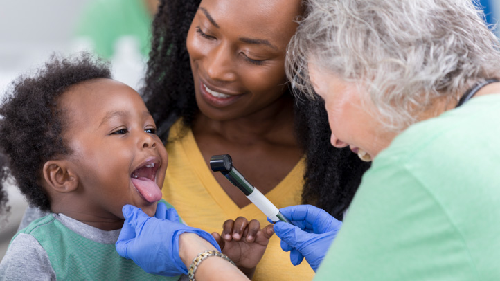 30-month checkup, little boy opening wide at the doctor's office