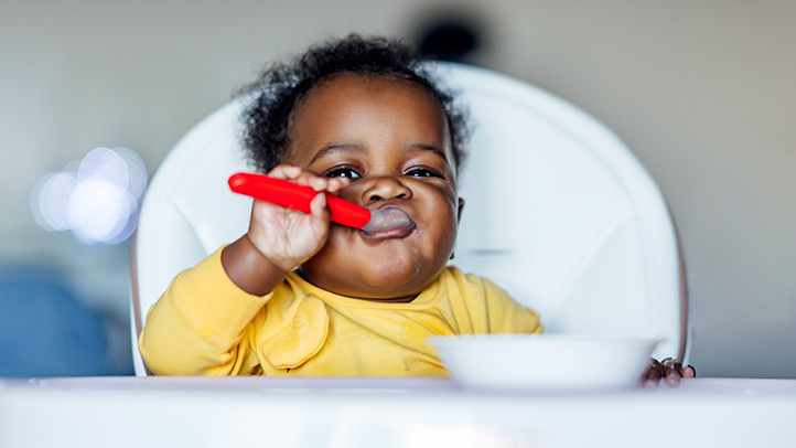 baby in high chair self-feeding