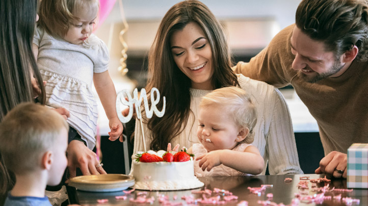 mom and baby at berry first birthday party with a strawberry cake