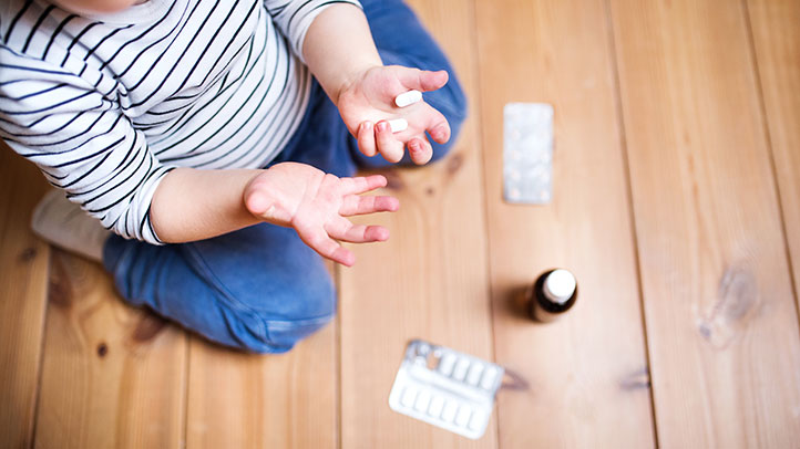 accidental childhood poisoning, toddler with medicine in hands