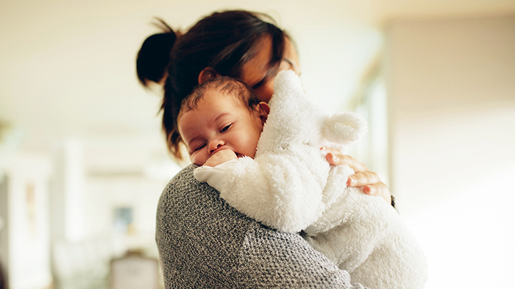 baby fighting sleep, sleepy baby held in mom's arms