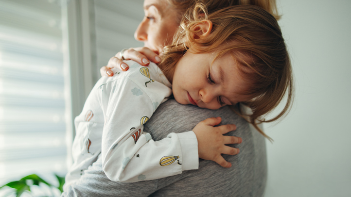 overtired toddler, sleep-deprived toddler, sleepy toddler girl being carried by mom