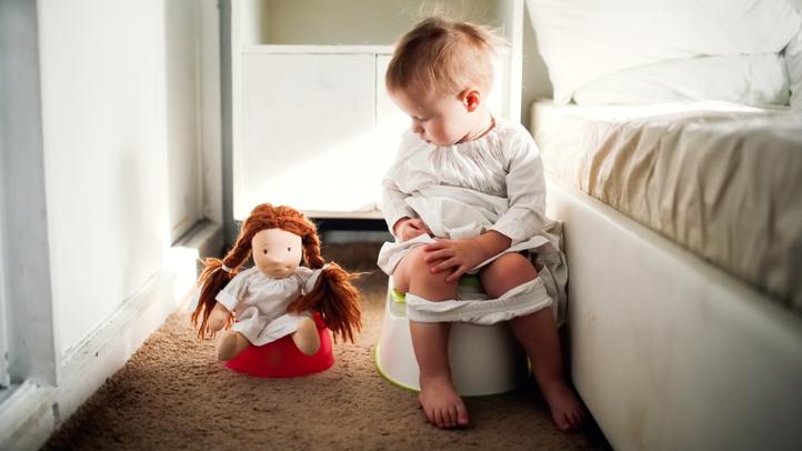 how to potty train a girl, little girl sitting on the potty with her doll on the potty