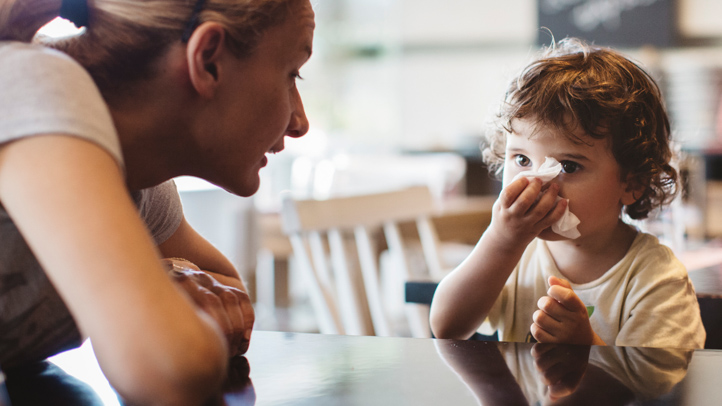 seasonal allergies in babies and toddlers, young toddler blowing his nose with mom looking on
