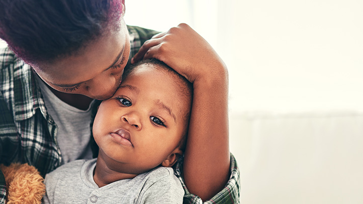 parent kissing baby, when is child too sick for day care